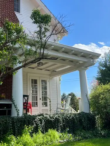 Inviting white porch under a bright blue sky.